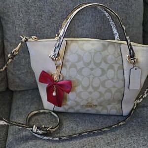 Elegant Cream Coach Handbag with Red Bow Accent